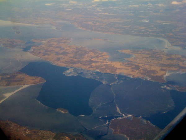 機窓から半分凍った Lake Champlain, Grand Isle を望む。
