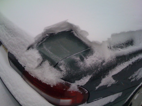 車の上の雪をおろしているところ。