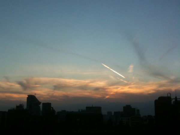 夕焼けに飛行機雲が輝きます。